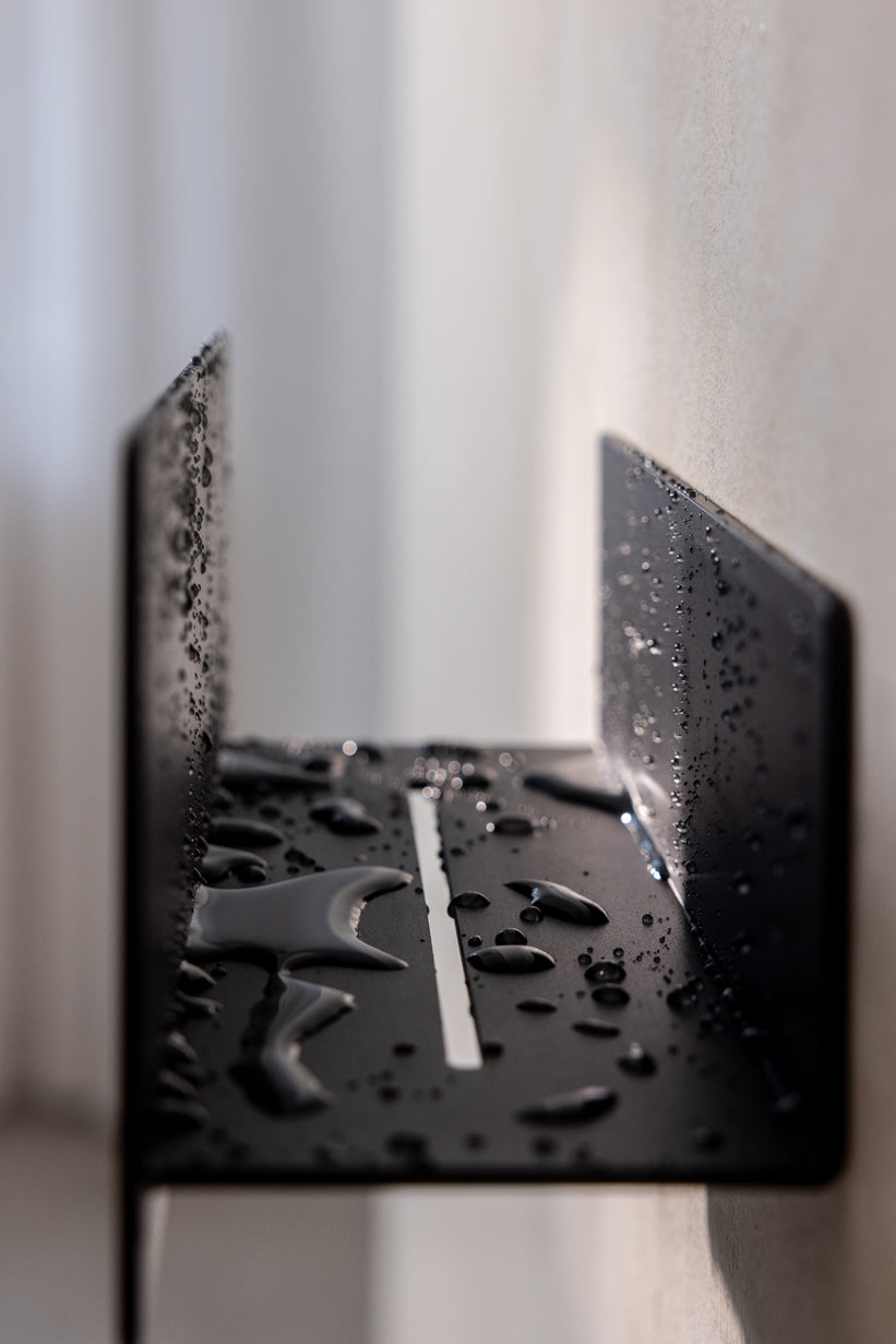 Sort brusehylde med rille til vandafløb