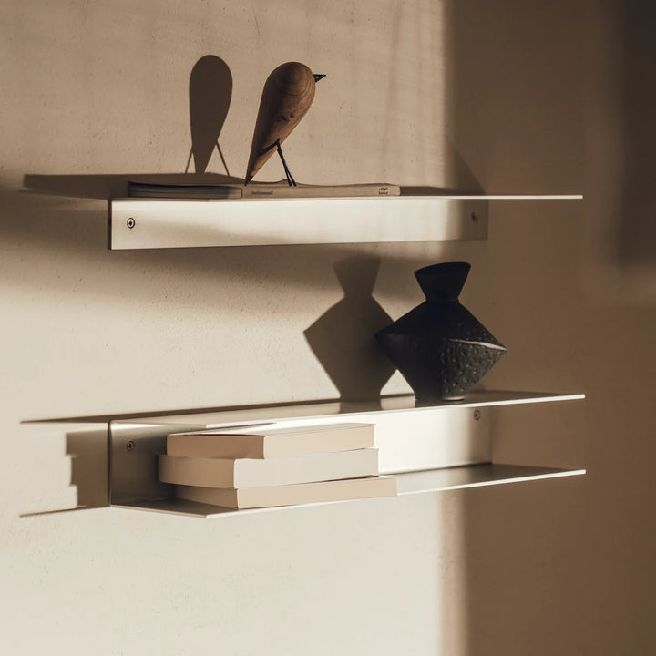 “RAWW C-formet væghylde brugt som natbord – funktionelt design i rå aluminium