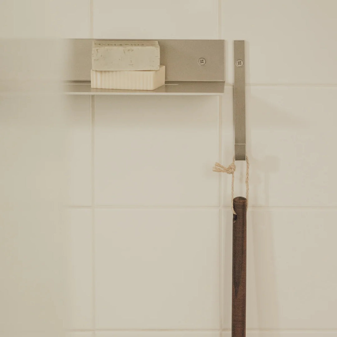 Detaljebillede af RAWW brusehylde – mat aluminiumsfinish med skjult vandafløb og skarpe linjer